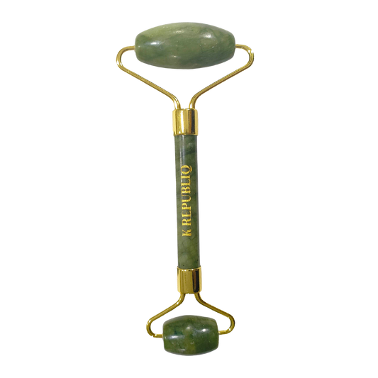 A green jade facial roller with a gold-colored metal handle.