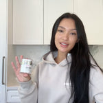 Woman with long straight hair holding K Republiq Glass Skin Finishing Glaze skincare product.