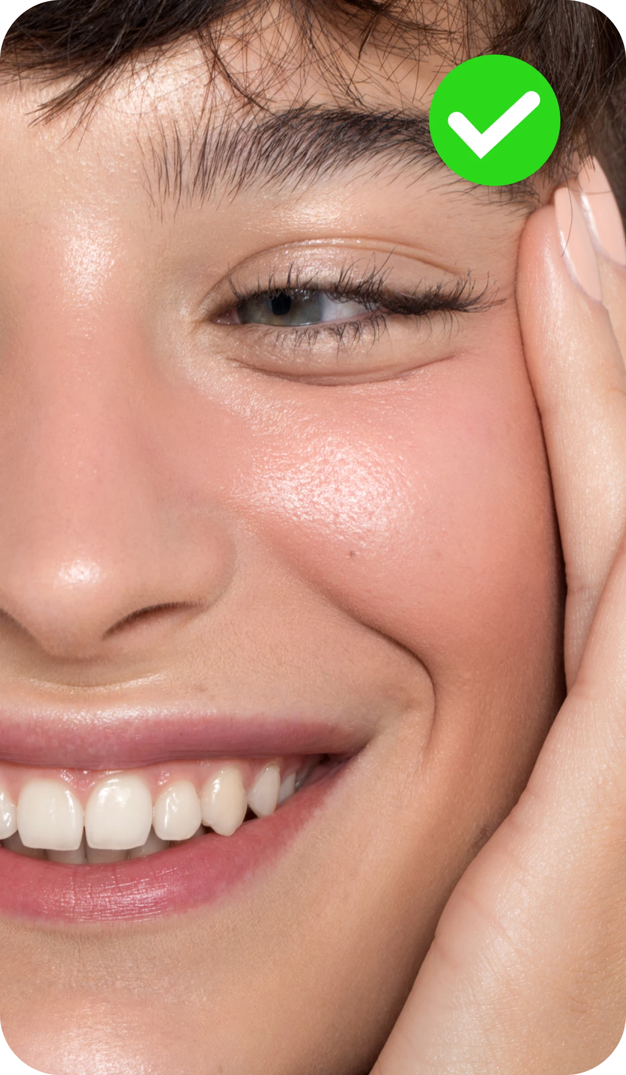 A close-up of a person's smiling face, with a hand touching their cheek. A green checkmark icon is in the top right corner of the image.