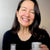 Smiling woman holding K Republiq Glass Skin Finishing Glaze skincare product
